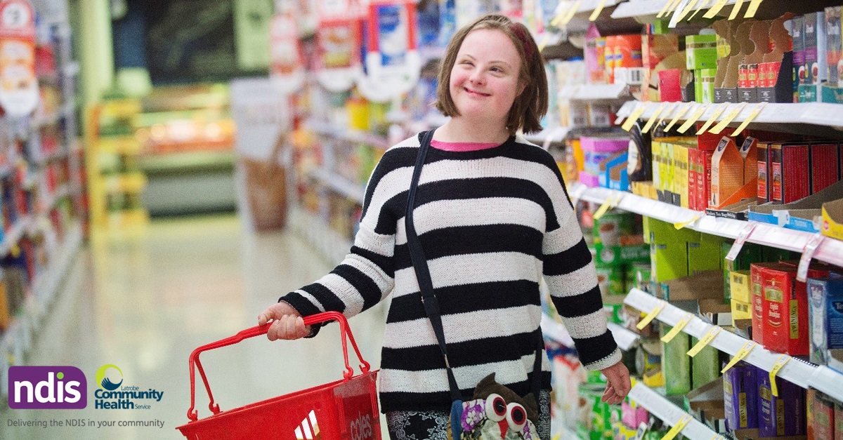 Young woman with disability carrying shopping basket in supermarket