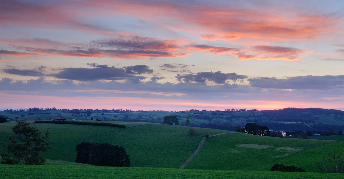 Photo of sunset over rolling green hills